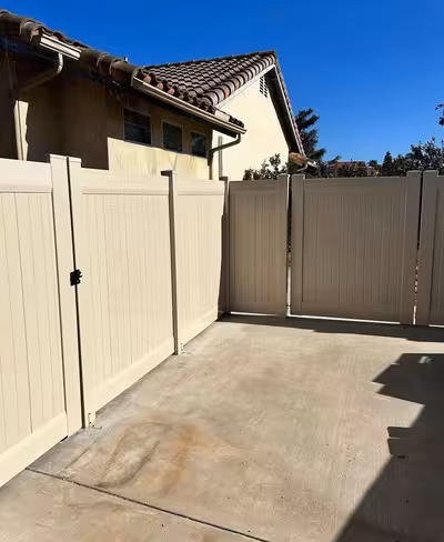 A privacy fence encompasses a driveway as the Californian sun beats down